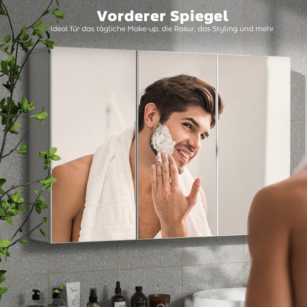 Dreitüriger Spiegelschrank im Badezimmer mit der Reflexion eines Mannes beim Rasieren.