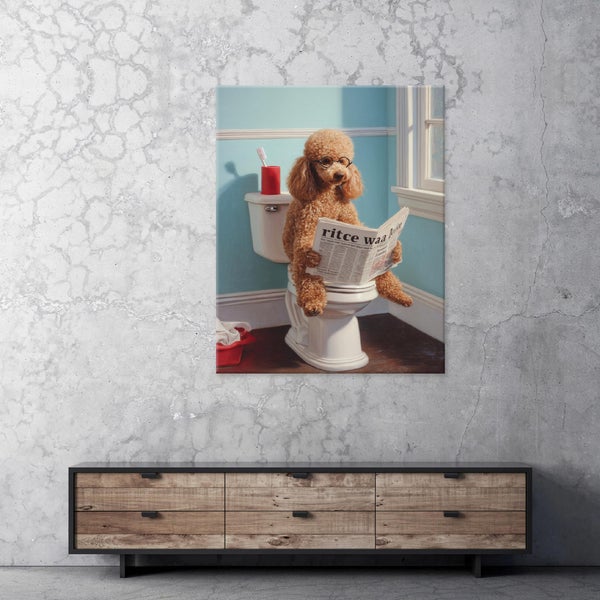 Wandbild mit einem Pudel, der mit Brille auf einer Toilette sitzt und Zeitung liest, an einer Betonwand über einer Kommode hängend.