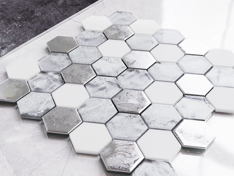 Hexagonale Mosaikfliesen in Weiß und Silberoptik mit verschiedenen Oberflächenstrukturen und Marmorierung.