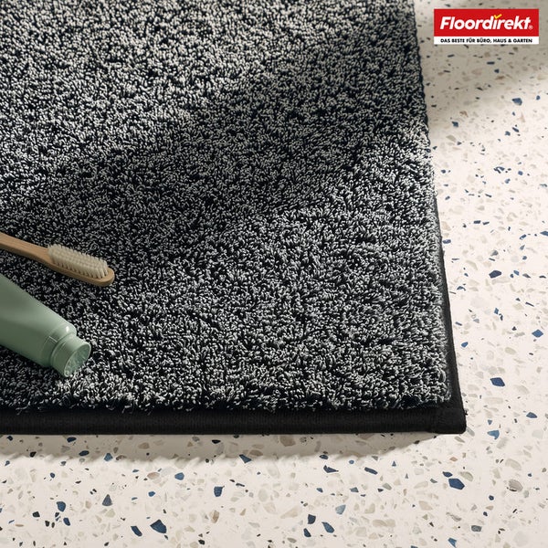 Grauer Badteppich mit Zahnbürste und Zahnpasta