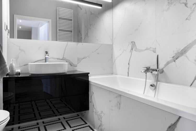 Modernes Badezimmer mit Badewanne, Waschtisch und Spiegel