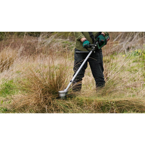 Rasentrimmer beim Schneiden von hohem Gras und Unkraut im Garten.