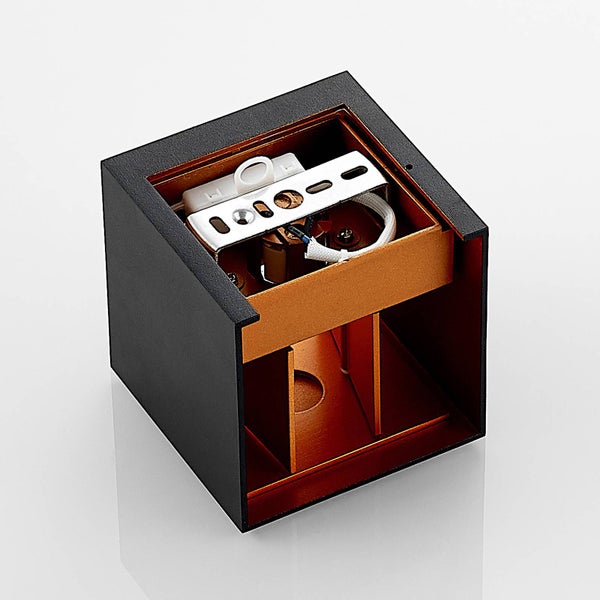 Würfelförmige Wandleuchte in Schwarz mit kupferfarbenem Innenraum, Ansicht der Montagehalterung und Verkabelung.