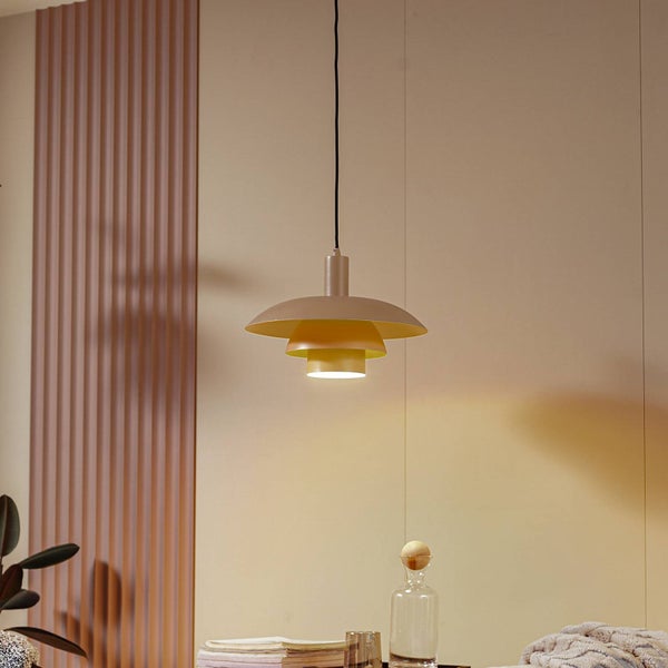 Mehrlagige Pendelleuchte im skandinavischen Design in einem hellen Raum mit vertikalen Wandpaneelen, Karaffe und Büchern.