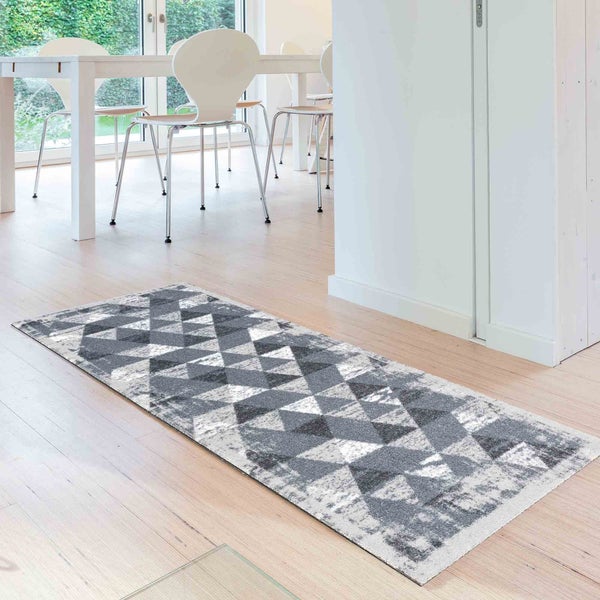 Läufer mit geometrischem Muster auf Holzboden in einem hellen Raum.