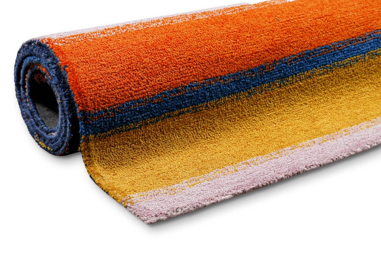 Zusammengerollter Teppich mit orangefarbenen, blauen, gelben und rosafarbenen Streifen.