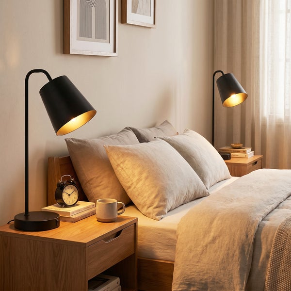 Modernes Schlafzimmer mit zwei Nachttischen aus Holz, darauf stehen jeweils eine schwarze Schreibtischlampe und Dekoration in heller Umgebung.