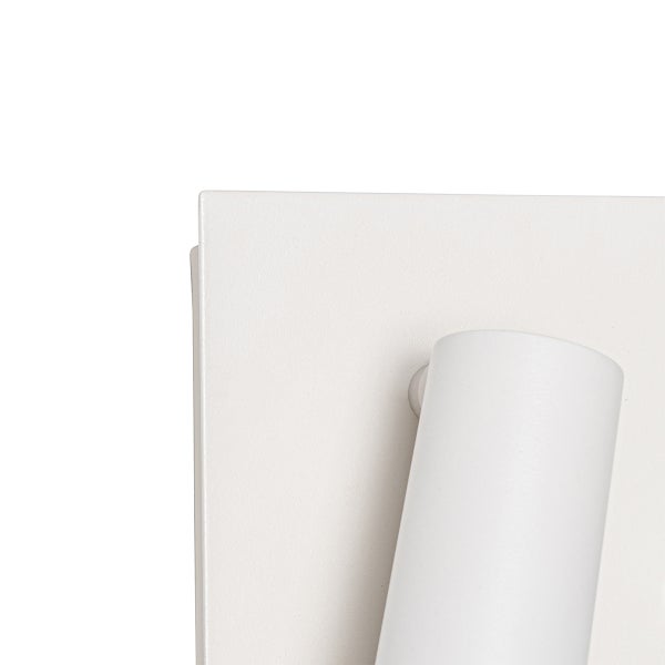 Detailaufnahme einer Wandleuchte mit rechteckiger Metallbasis und zylindrischem Strahlerkopf.