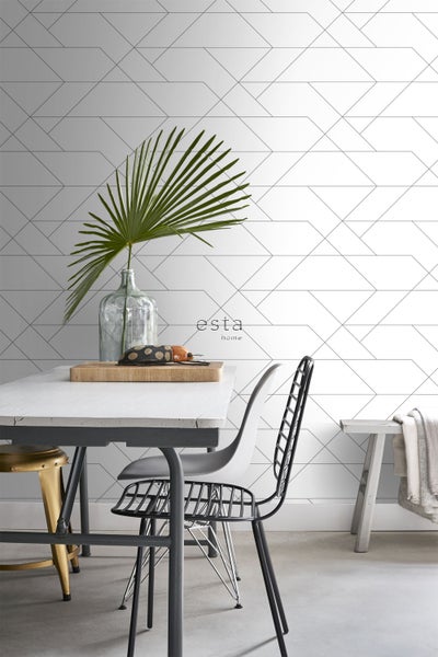 Esstisch mit Stühlen vor einer Wand mit geometrischer Tapete und Esta Home Logo