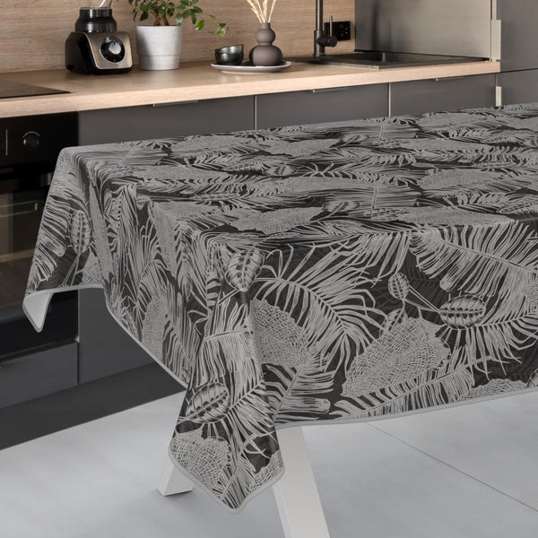 Tischdecke mit tropischem Blättermuster in einer modernen Küche auf einem Tisch ausgebreitet.