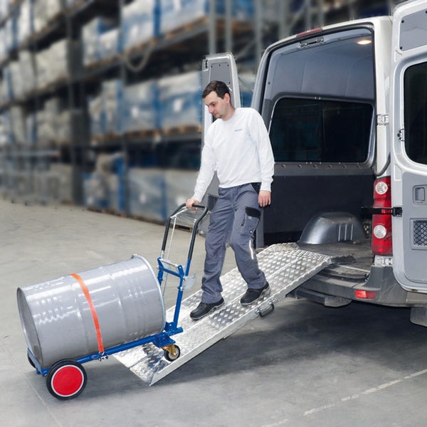 Verladerampe aus Aluminium für Transporter, ein Arbeiter schiebt ein Metallfass auf einer Sackkarre über die Rampe in einem Lager.