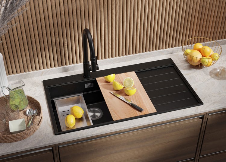 Küchenszene mit Spüle, Armatur, Schneidebrett und Zitronen auf einer Arbeitsplatte