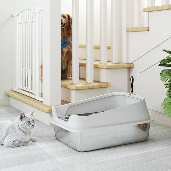 Edelstahl-Katzenklo mit hohem Aufsatz und Streuschaufel neben einer Treppe mit Schutzgitter sowie Katze und Hund.