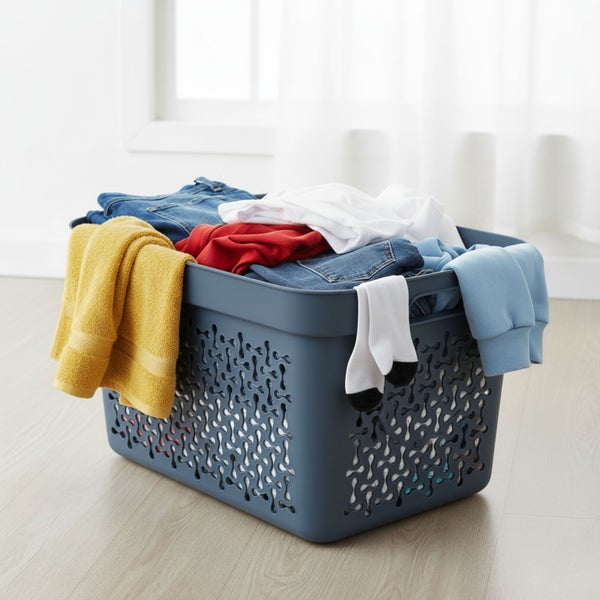 Wäschekorb gefüllt mit Kleidung im Zimmer