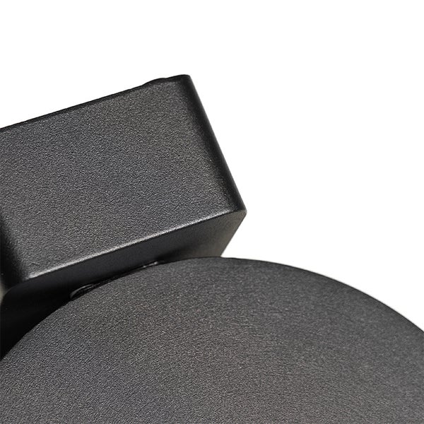 Detailansicht einer schwarzen, matt pulverbeschichteten Wandleuchte aus Metall mit strukturierter Oberfläche.