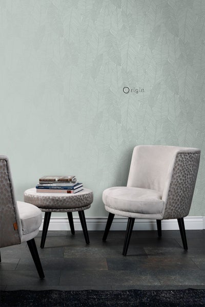 Raumansicht mit gemusterter Tapete, Sessel und Beistelltisch