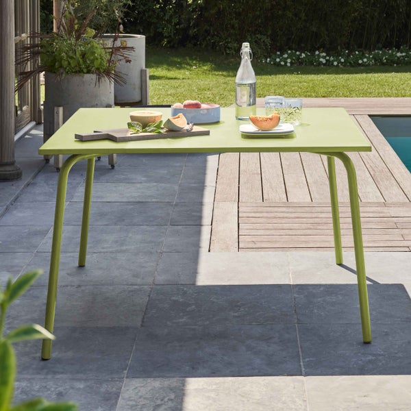 Rechteckiger grüner Metall-Gartentisch auf einer Terrasse mit Steinplatten und Holzdeck neben einem Pool, gedeckt mit Obst und Getränken.