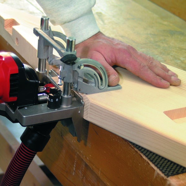 Handwerker bei der Arbeit mit einer Flachdübelfräse an einem Holzbrett in einer Werkstatt.