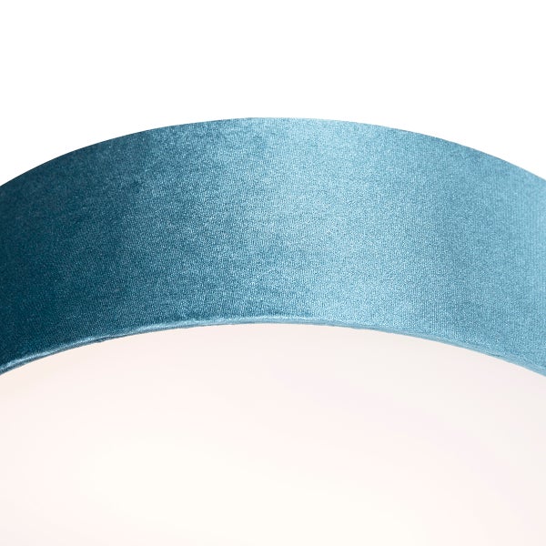 Nahaufnahme eines Lampenschirms aus blauem Stoff mit Satin-Oberfläche.