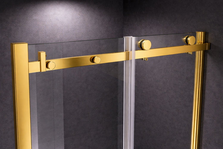 Detailansicht einer Duschkabine mit goldfarbenen Metallprofilen und sichtbarem Rollensystem für die Schiebetür aus Klarglas.