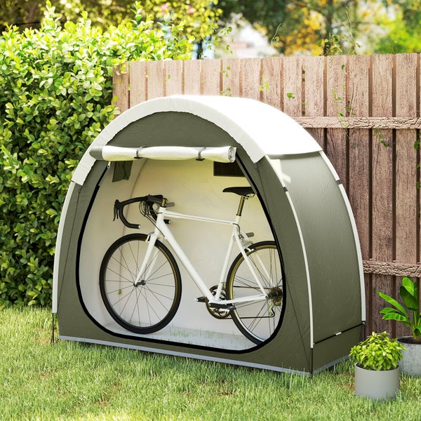 Graue Fahrradgarage in Zeltform aus Textil mit einem weißen Fahrrad darin vor einem Holzzaun im Garten.