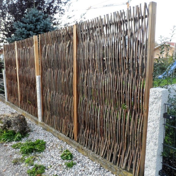 Sichtschutzzaun aus Weide mit Holzrahmen und Steinpfosten