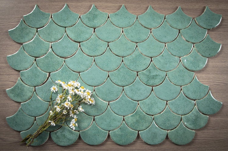 Muster aus grünen, fächerförmigen Keramikfliesen mit Blumenstrauß