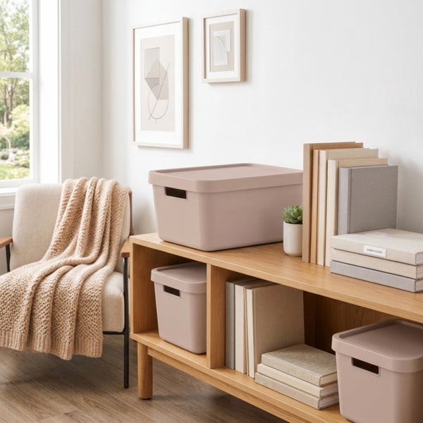 Moderne Aufbewahrungsboxen mit Deckel auf einem Holzregal in einem organisierten Wohnbereich mit Sessel und Dekoration.