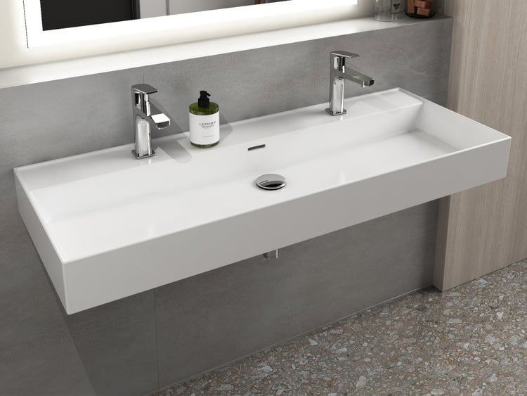 Modernes, rechteckiges Doppelwaschbecken zur Wandmontage mit zwei verchromten Armaturen in einem Badezimmer.