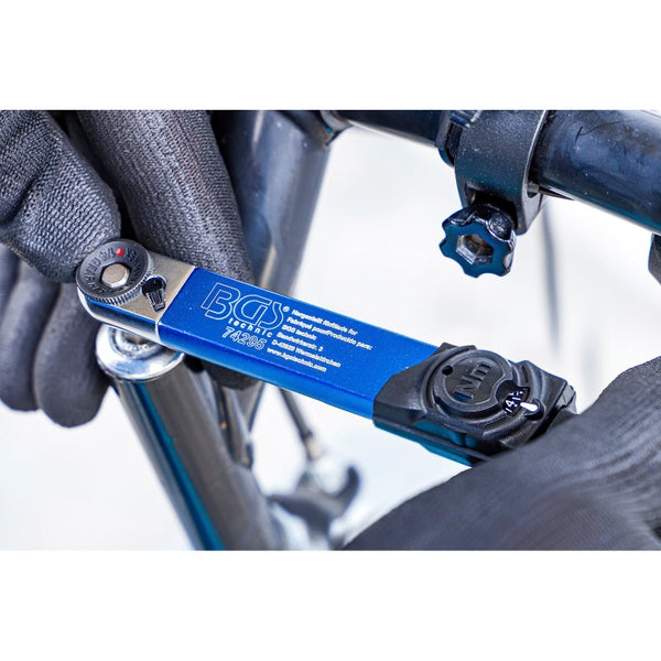 Nahaufnahme eines Drehmomentschlüssels der Marke BGS Technic beim Anziehen einer Schraube an einem Fahrrad.