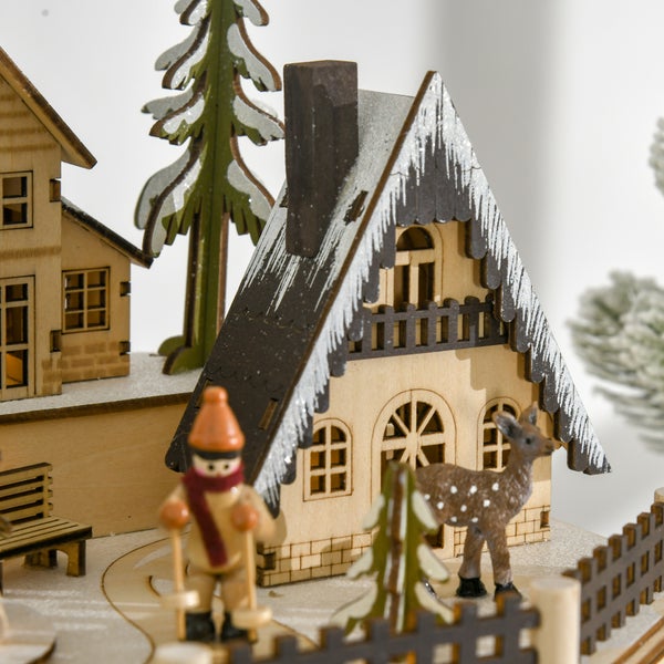 Dekorative Winterlandschaft aus Holz mit Haus, Skifahrer, Reh und verschneiten Tannen.
