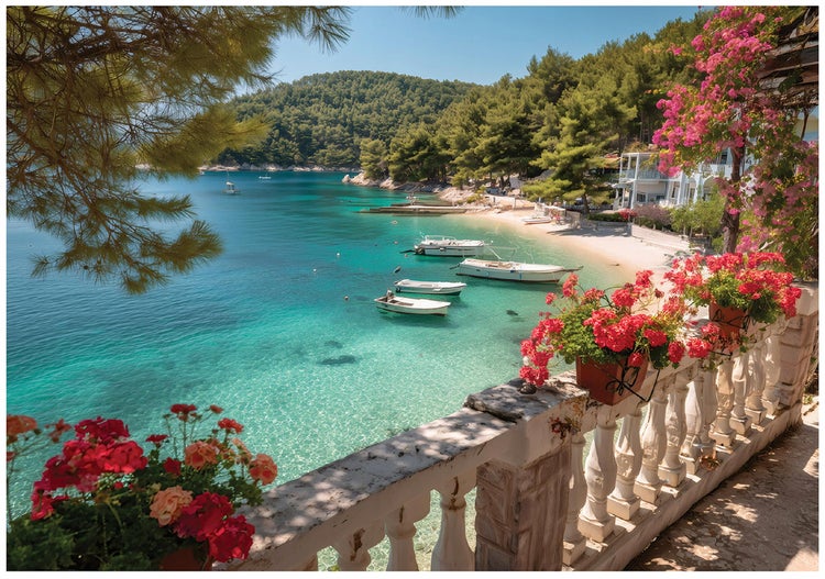 Blick von einem Steinbalkon mit roten Blumen auf eine Meeresbucht mit klarem Wasser, kleinen Booten und bewaldeten Hügeln.