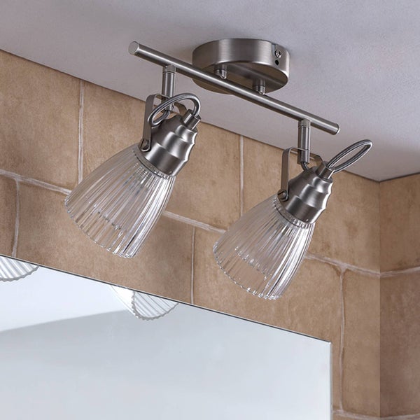 Moderne Deckenleuchte 2-flammig mit verstellbaren Strahlern aus Metall und gerippten Glasschirmen über einem Spiegel im Badezimmer.