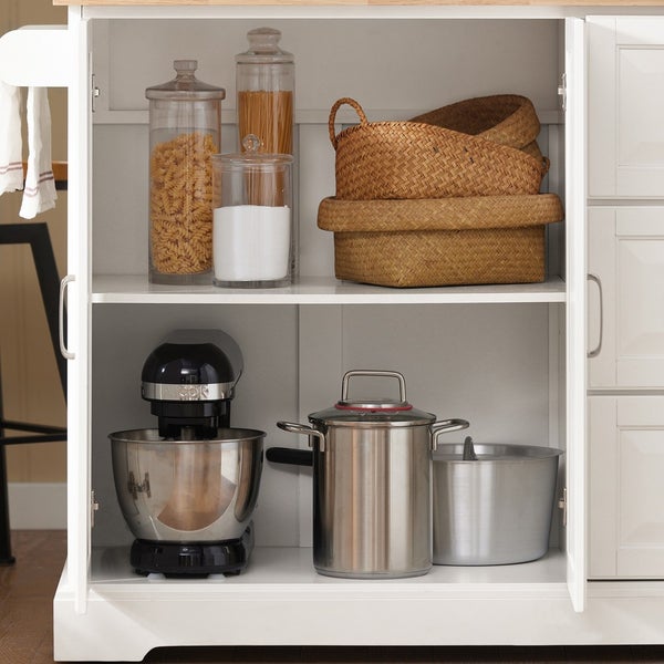 Innenansicht eines Küchenschranks mit Vorratsgläsern, Schüsseln, einer Küchenmaschine und Kochtöpfen