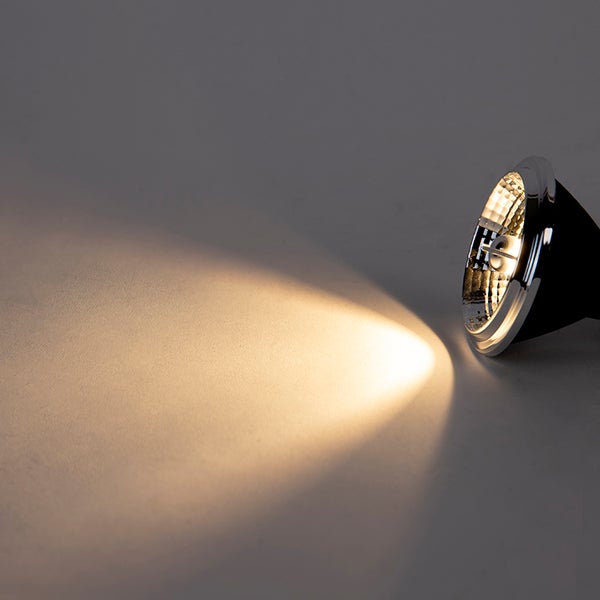 Eingeschaltete LED Reflektorlampe mit warmweißem Lichtkegel und verchromtem Rand.