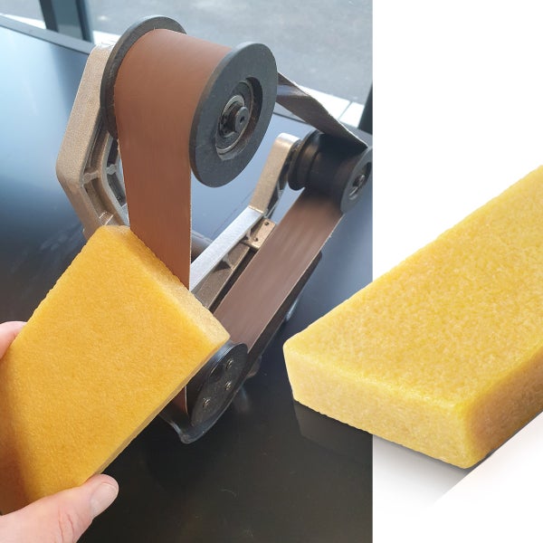 Reinigungsgummi für Schleifbänder bei der Anwendung an einer Bandschleifmaschine.