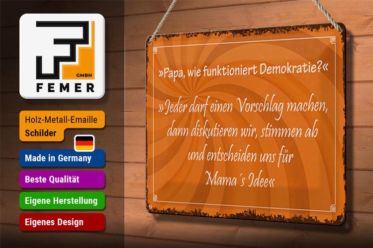 Metallschild mit der Aufschrift: Papa, wie funktioniert Demokratie? Jeder darf einen Vorschlag machen, dann diskutieren wir, stimmen ab und entscheiden uns für Mamas Idee.