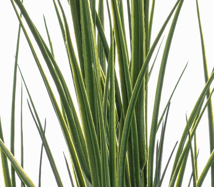 Detailansicht von langen, grünen Kunstgrashalmen mit hellen Rändern.