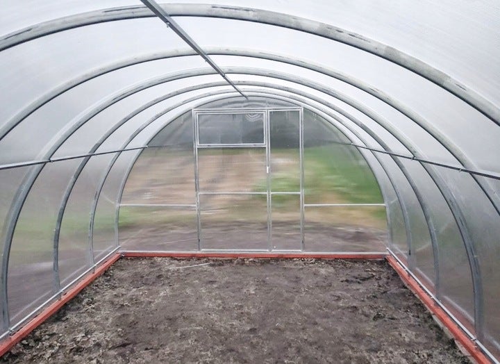 Innenansicht eines Gewächshauses mit Tür und durchscheinenden Wänden