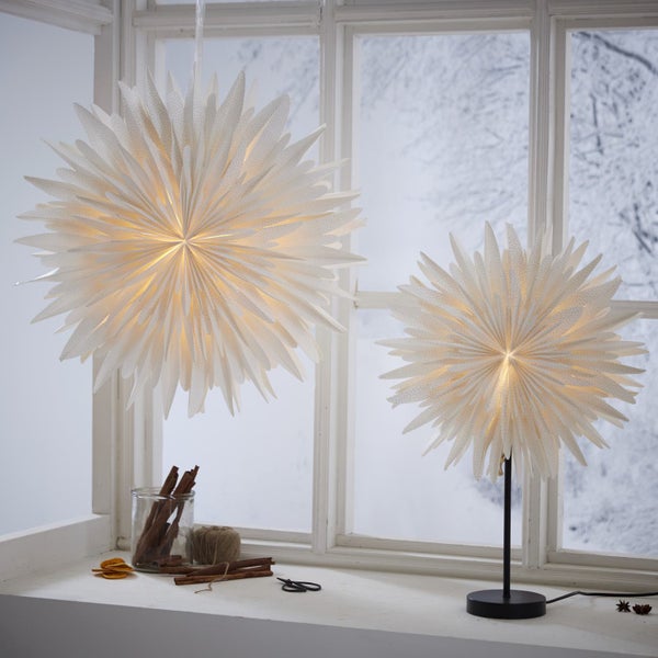 Dekorative Szene mit Papiersternleuchten auf einer Fensterbank