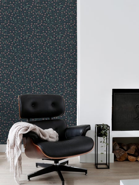 Wohnzimmer mit gemusterter Tapete, Sessel und Kamin