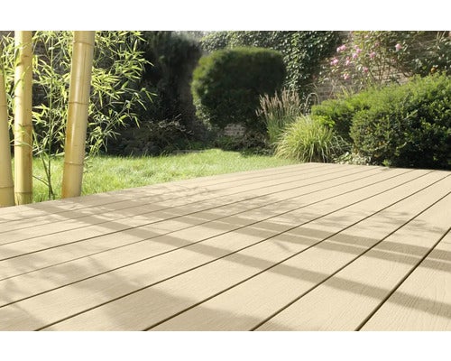 Helle Terrassendielen in einem hellen, organisierten Garten mit Rasenfläche, Bambus und Sträuchern.
