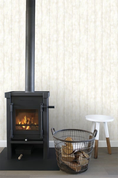 Innenaufnahme mit Kaminofen, Holzkorb und Hocker