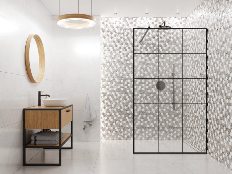Modernes Badezimmer mit Holzwaschtisch, Aufsatzbecken, Rundspiegel und begehbarer Dusche mit schwarzer Glaswand und Sechseck-Fliesen.