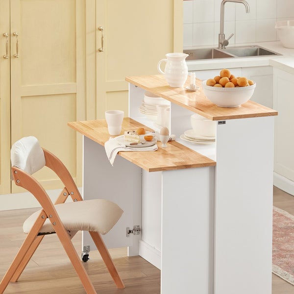 Küchenszene mit Bartisch, Klappstuhl, Geschirr und Speisen.