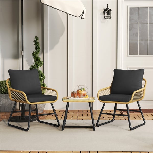 Terrassenszene mit zwei Stühlen mit Kissen und einem Tisch mit Getränken.