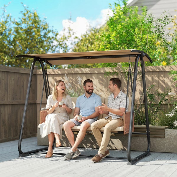 Drei Personen sitzen auf einer dreisitzigen Garten-Hollywoodschaukel mit Sonnendach auf einer Holzterrasse im Garten.