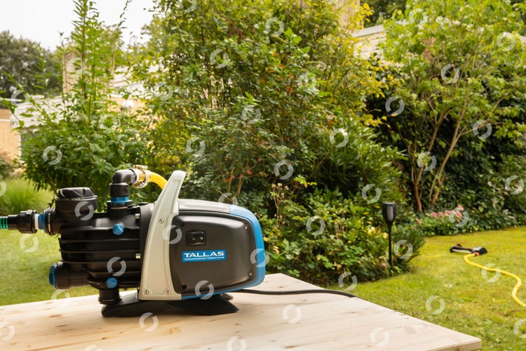 Tallas Gartenpumpe auf einem Holztisch in einem Garten
