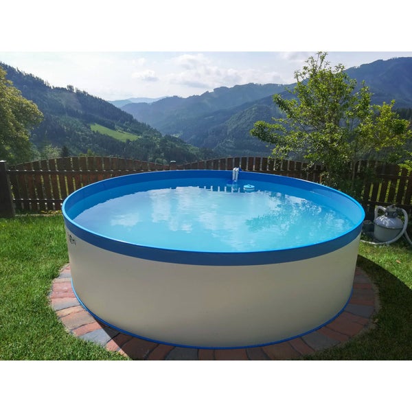 Rundes Schwimmbecken im Garten mit Berglandschaft im Hintergrund.