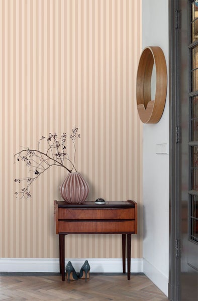 Raumansicht mit gestreifter Tapete, Kommode, Spiegel und Dekoration